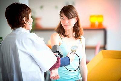 Doctor checking the blood pressure of a female patient.-stock-photo