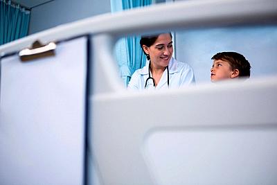 Smiling doctor interacting with patient in ward-stock-photo