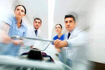 health care, reanimation and medicine concept - group of medics or doctors carrying unconscious woman patient on hospital gurney to emergency (motion ...-stock-photo