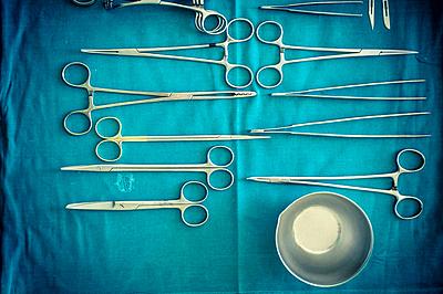 surgical instruments and tools including scalpels, forceps and tweezers arranged on a table for a surgery-stock-photo