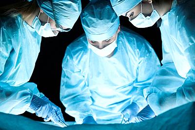 Medical team performing operation. Group of surgeon at work in operating theatre toned in blue-stock-photo